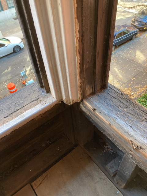 A rotted window sill at one of the bay's corners