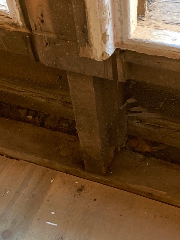 Close-up of the rotted, patched-together post supporting the bay window
