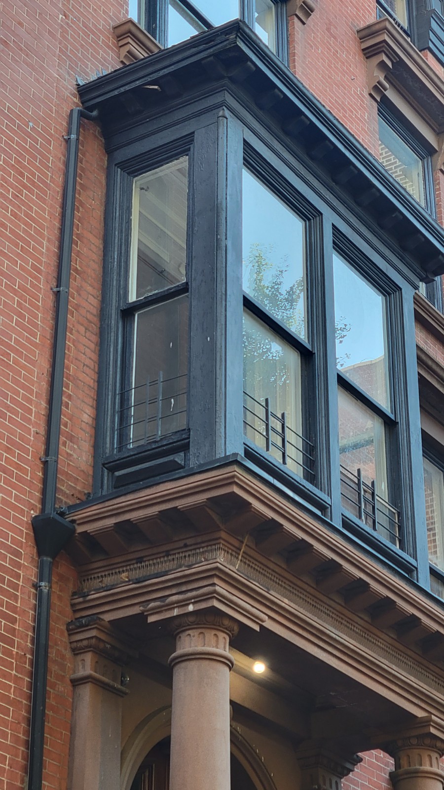 The bay's cornice and corner detail, seen from below